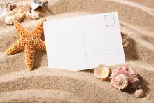 Eine Postkarte im Sand.