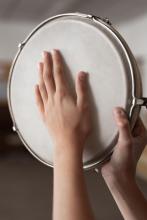 Eine Hand schlägt auf eine Trommel.