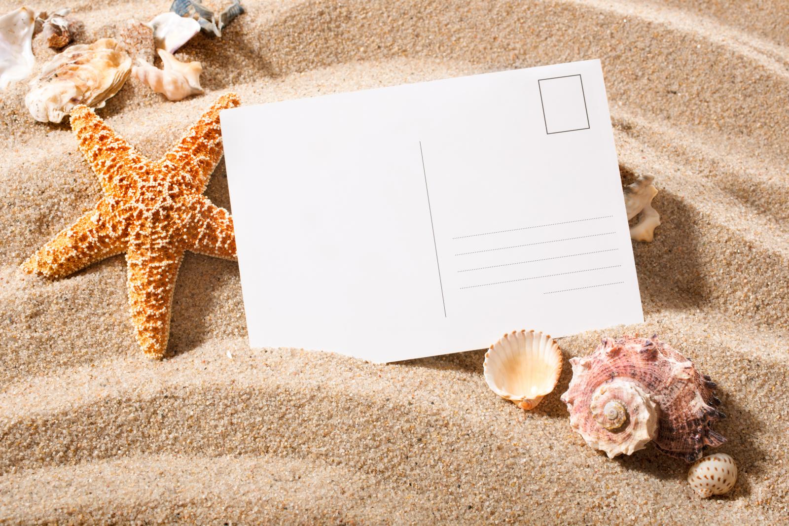 Eine Postkarte im Sand.