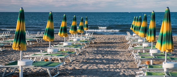 Grün-gelbe Sonnenschirme am Strand.